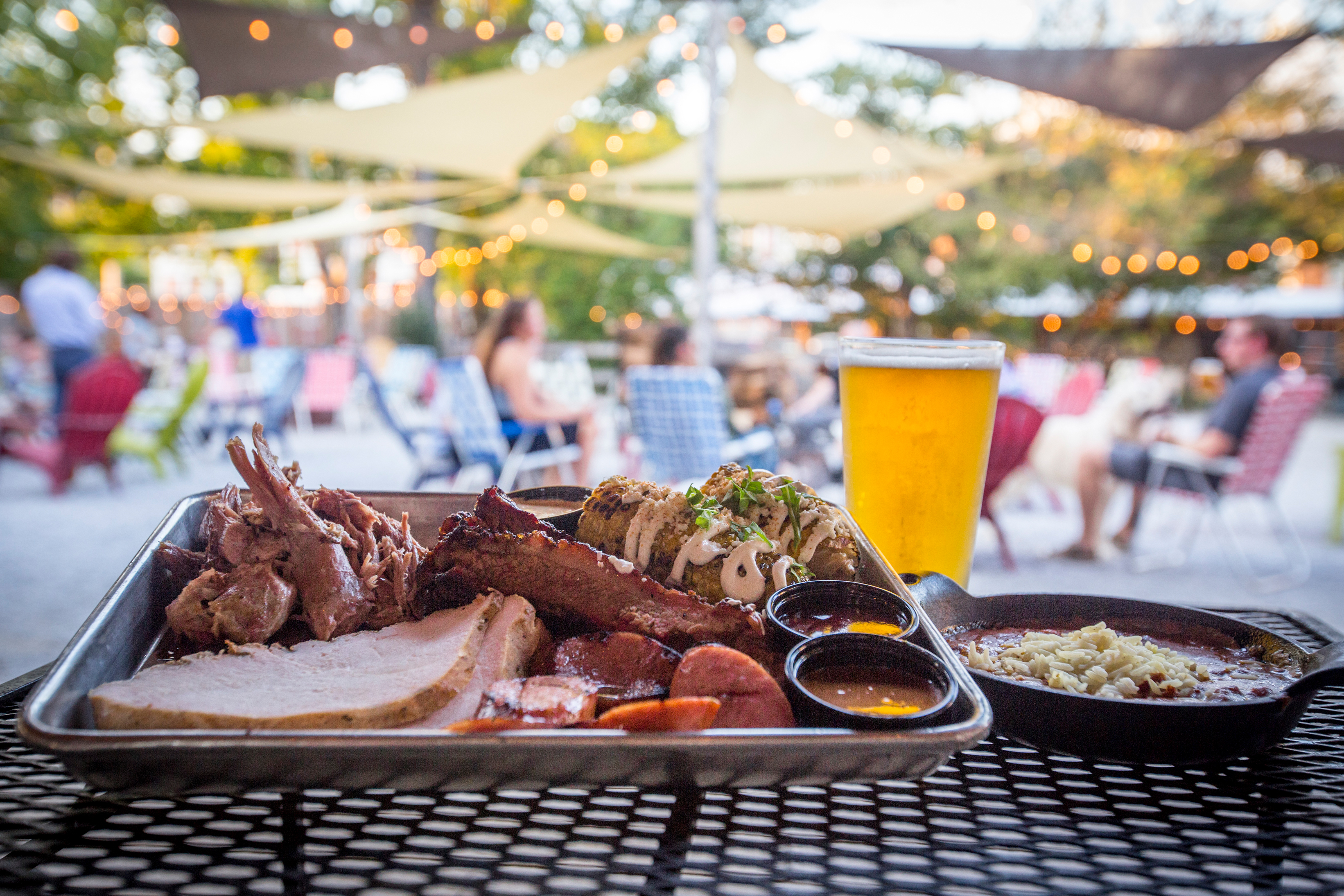 meat platter on table with loflin patio in background and string lights