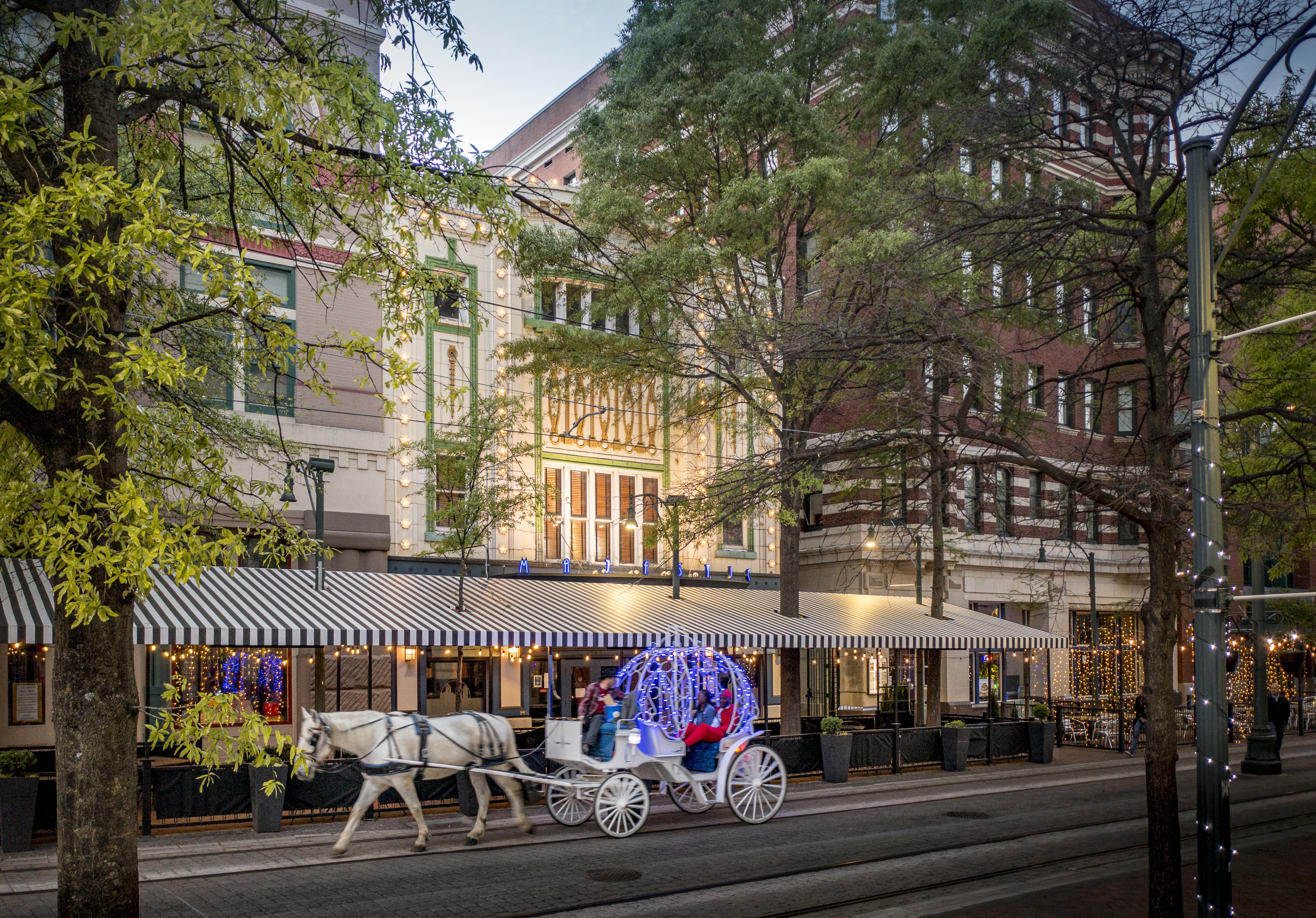 lit up horse carriage walks in front of majestic grille patio