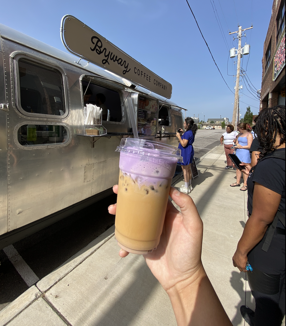 airstream coffee stand with ube iced latte held up