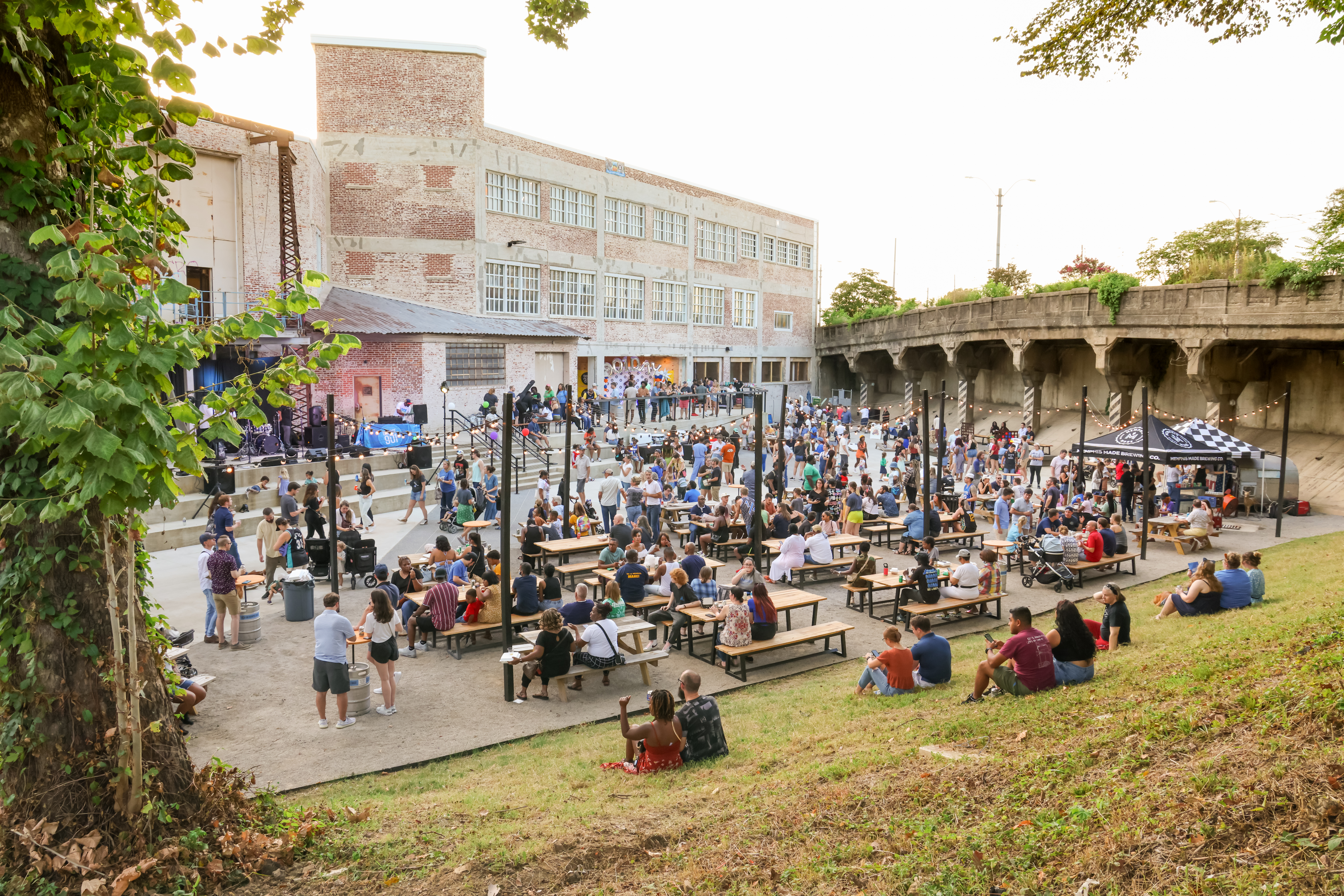 people sitting at picnic tables in the ravine at memphis made
