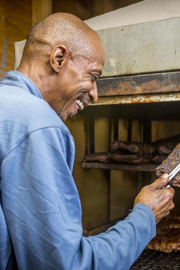 Pit master tending to ribs at Cozy Corner restaurant