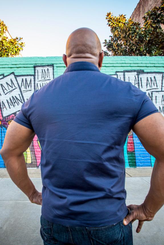 man facing the I AM Man Mural 