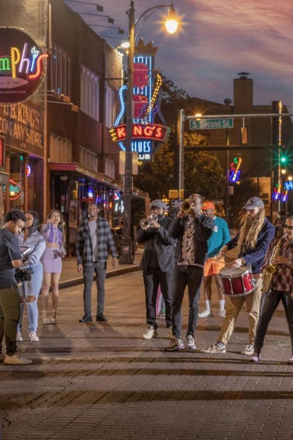 Brass band performing on Beale Street at dusk