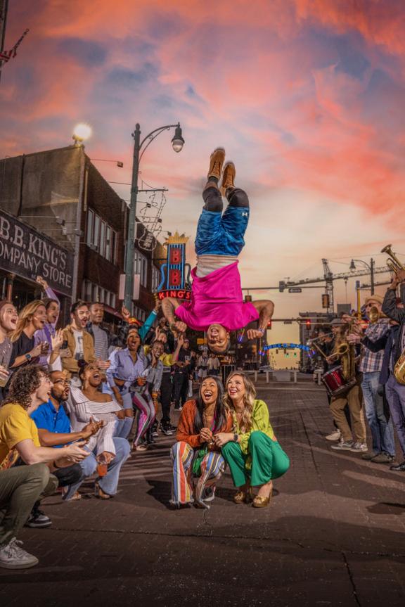 A Beale Street Flipper performs acrobatics over a crowd of onlookers on Beale Street in Memphis, Tennessee, at sunset..