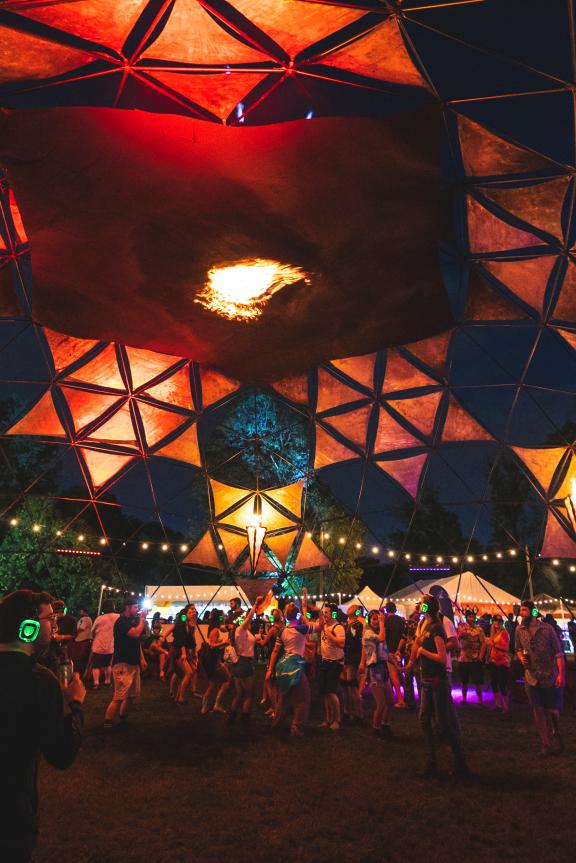 The Incendia Dome at Mempho Music Fest glows at night, crowds dancing within it.