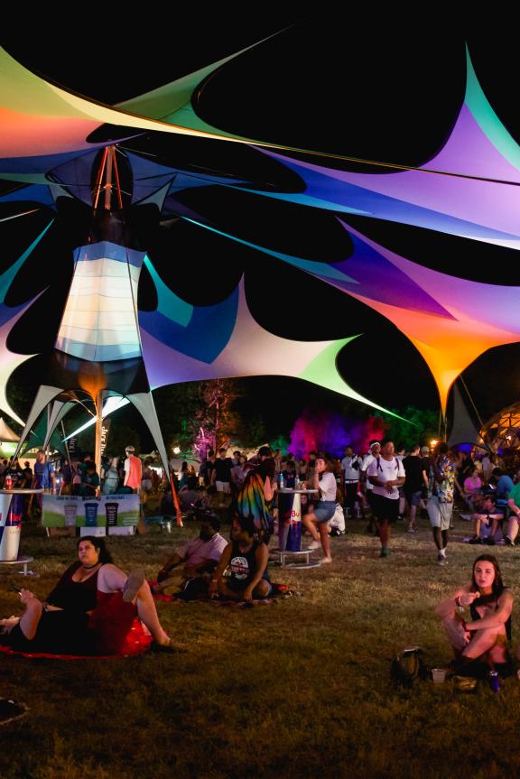 Guests relax around the grounds of Mempho Music Festival. Multicolored tents provide shade.