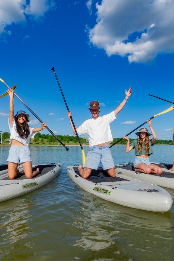 a group of paddle boarders post for photo at Shelby Farms Park