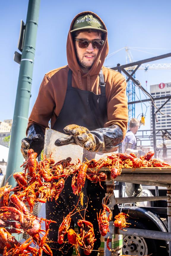 man pushes crawfish into bucket