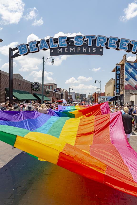 massive pride flag being held up during pride parade on beale street