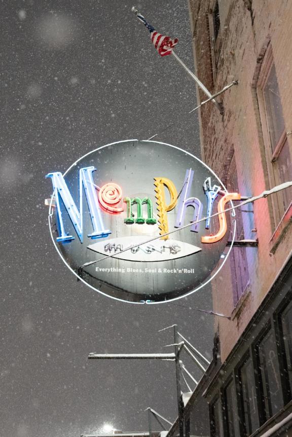 Neon Memphis Music sign on Beale Street with snow falling around it. 