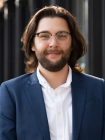 Dakota Averett headshot blue blazer shoulder length brown hair and glasses