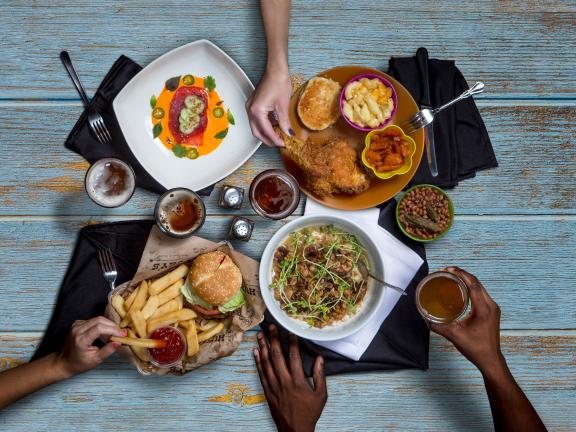 Hands reaching for food on a table
