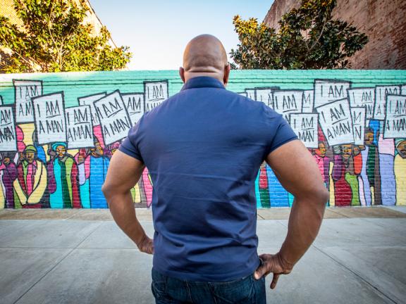 man facing the I AM Man Mural