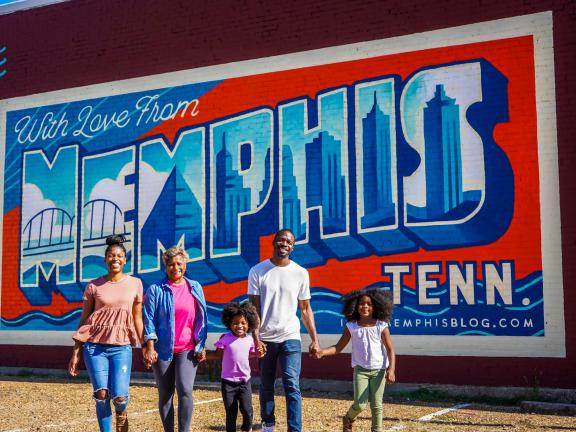 family of five stands in front of with love from memphis mural