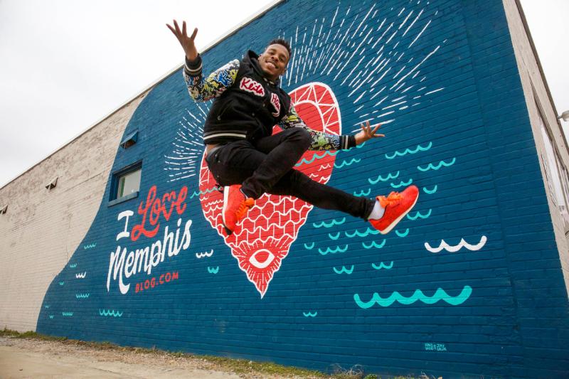 Memphis jookin dancer leaping in front of a mural