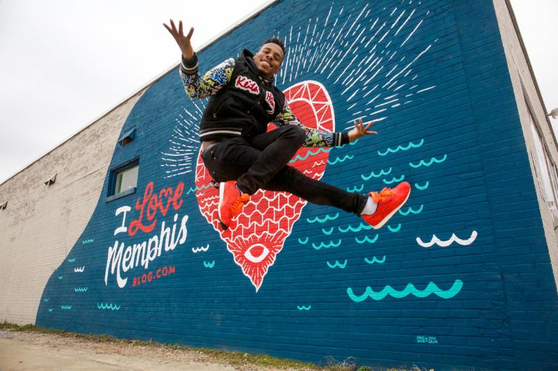 Memphis jookin dancer leaping in front of a mural