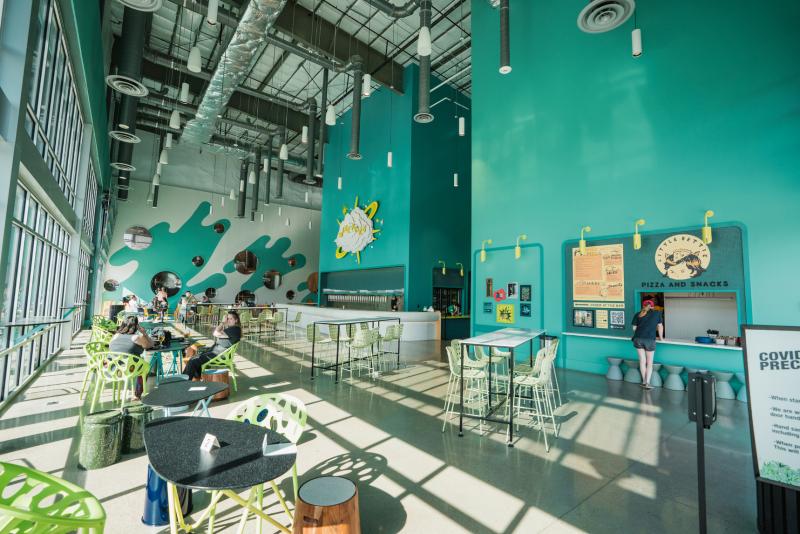 inside of brewery with industrial decor and bright teal walls