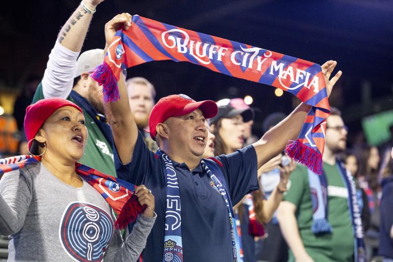 901 fc fan in red hat holds up scarf that reads Bluff City Mafia