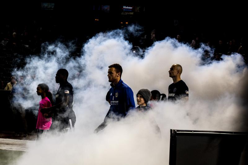 901 fc soccer players step out onto the field from a cloud of smoke