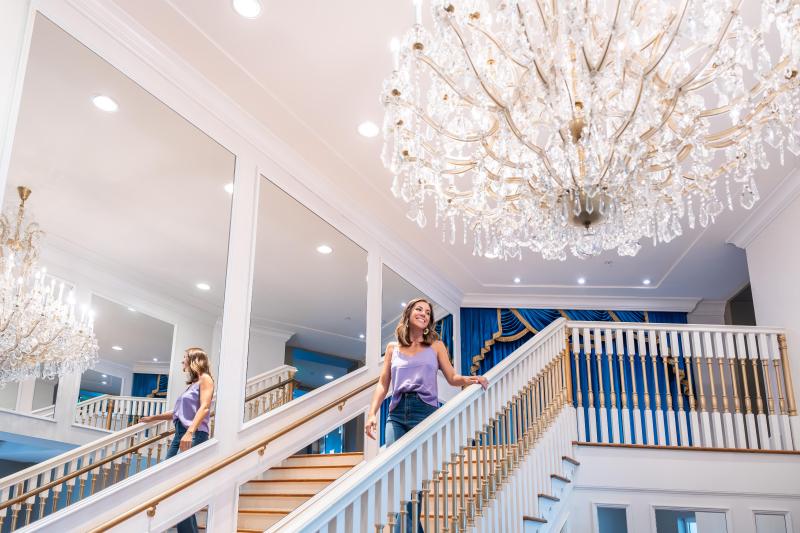 woman walks down the steps of Guest House at Graceland which mimics the famous Graceland staircase