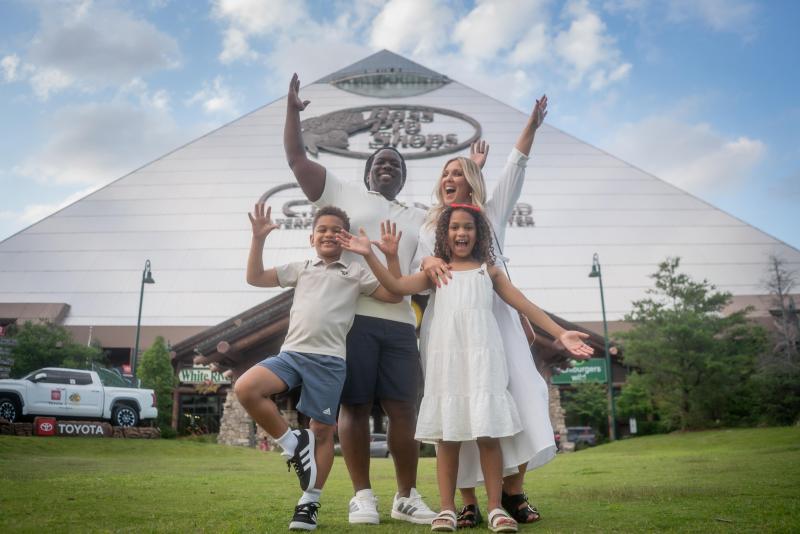 Family poses in front of Bass Pro Shops at the Pyramid.