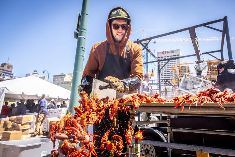 man pushes crawfish into bucket
