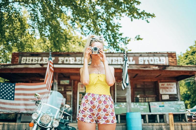 A woman takes a pic in front of the Shelby Forest General Store.