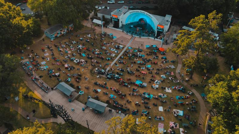 aerial daytime shot of overton park shell during a concert, people watching show