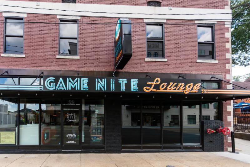 Game Nite Loung Building Exterior - Brick Building with Neon Sign Saying "Game Nite Loung" IN blue and Orange Lettering