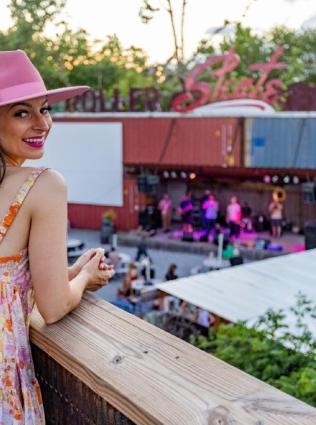 A woman enjoying live music at Railgarten, an outdoor music venue paired with a restaurant and bar in Memphis' Cooper-Young neighborhood