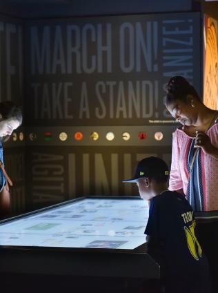 Museum visitors looking at interactive displays at National Civil Rights Museum.