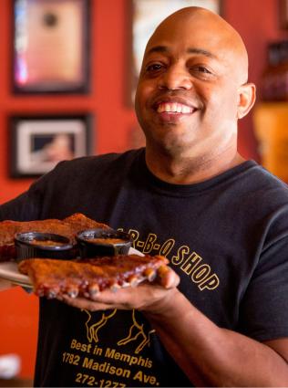 man holds up ribs 