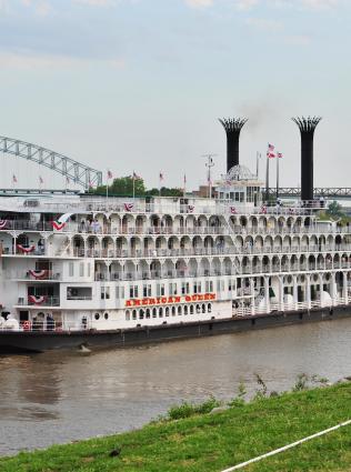 American river boat on water in front of M bridge