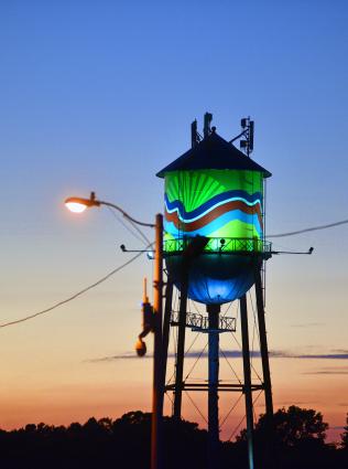 water tower lit up at sunset
