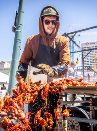 A man dumps a heap of crawfish onto newspaper at Memphis' Rajun Cajun Crawfish Festival