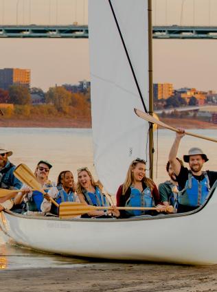 Paddlers cheering while in a canoe