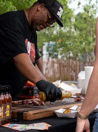 Man serving food at the SmokeSlame BBQ Festival