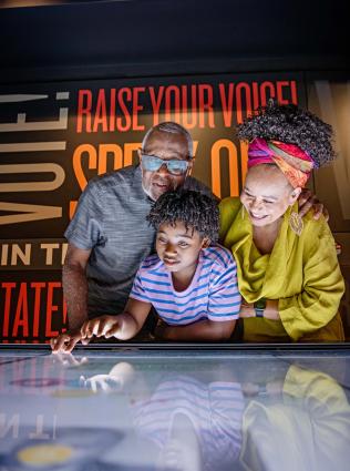 grandparents with child looks at interactive board at National Civil Rights Museum