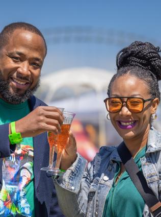 couple smiles with mimosas at mimosa festival