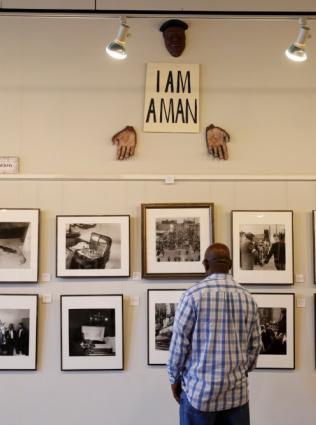A man looking at a wall of historic photos inside the Withers Collection Gallery & Museum.