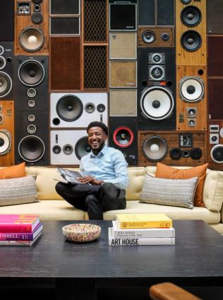 man sitting in front of music stereo backdrop