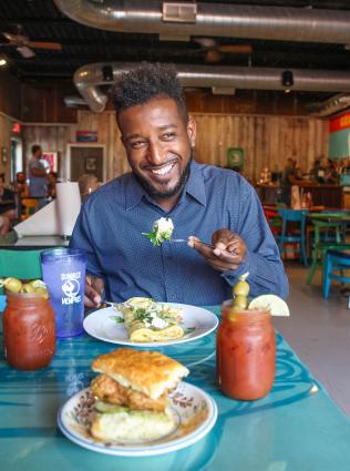 man sits at table eating at sunrise restaurant with biscuits