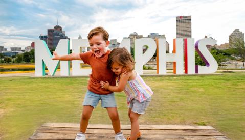 Kids pose in front of Memphis Sign on Mud Island