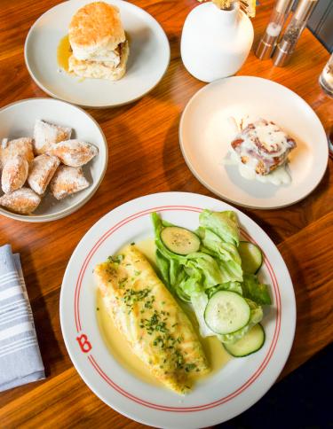 table with omelet, chicken biscuit, and brunch items at Bishop restaurant