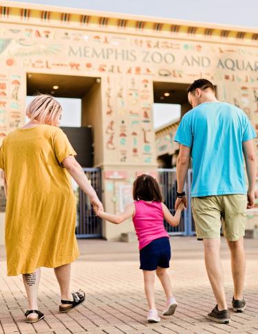 A family walking into the front gates of Memphis Zoo. | Memphis Zoo