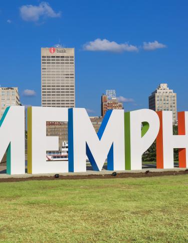 Photo of the "Memphis" letters on Mud Island with the city skyline in the background