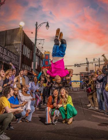 A Beale Street Flipper performs acrobatics over a crowd of onlookers on Beale Street in Memphis, Tennessee, at sunset..