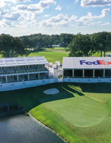 aerial shot of golf course with Fedex bleachers/booths next to hole