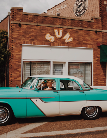 vintage blue car parked outside sun studio