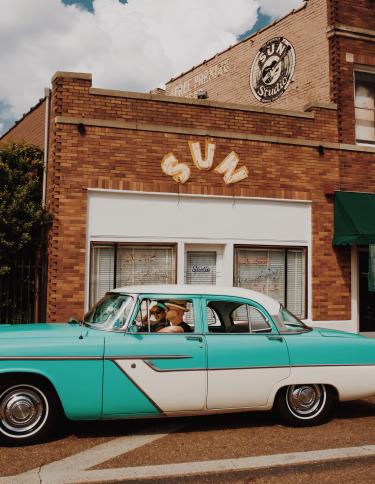 blue vintage car outside sun studio